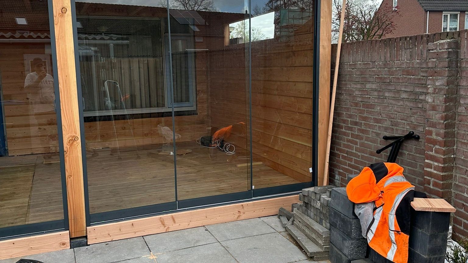 Veranda met glazen schuifwand gemaakt door TJ Bouwbedrijf